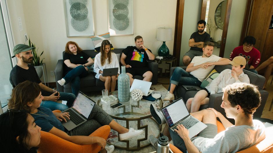 Um grupo diversificado de adultos colaborando em um ambiente de escritório em casa relaxado.