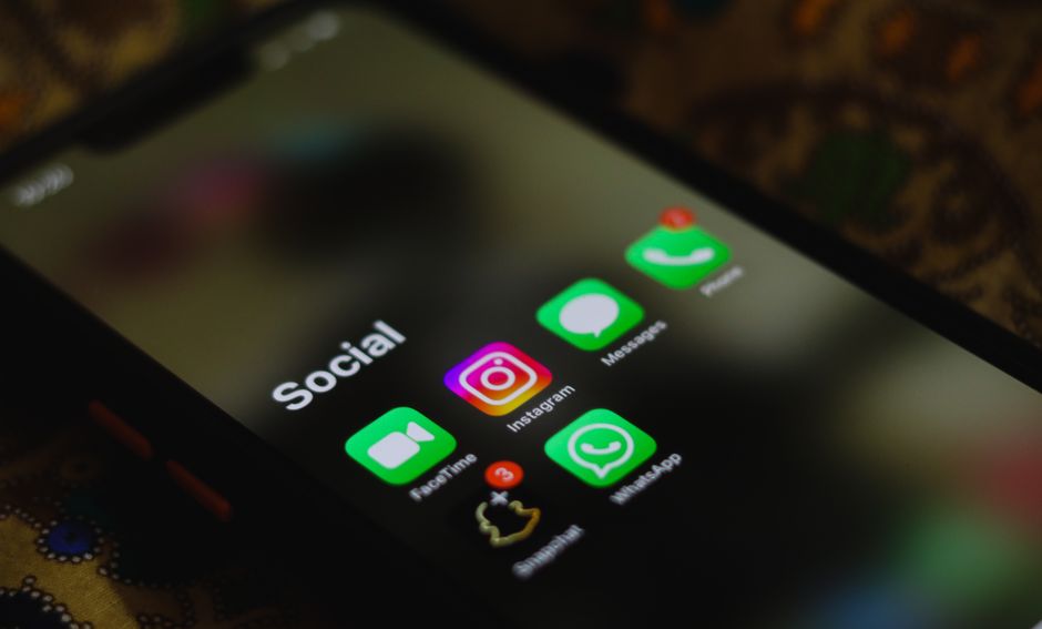 Uma imagem em close de um smartphone exibindo ícones de aplicativos de mídias sociais na tela.
