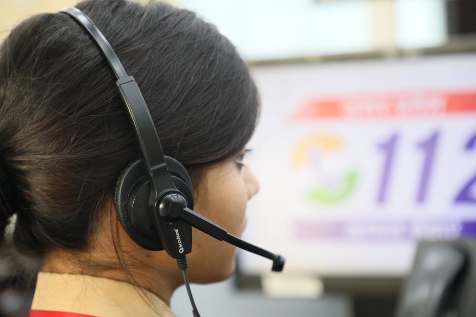 Close-up de uma mulher usando um fone de ouvido em um call center, destacando o atendimento ao cliente.